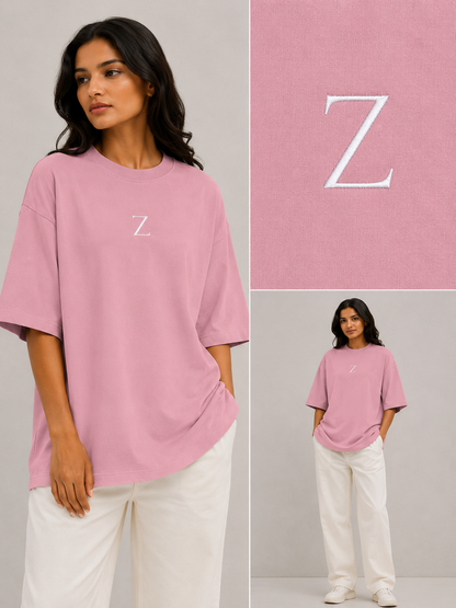 Zeroform Woman wearing a pink t-shirt with a white 'Z' logo, standing against a gray background.