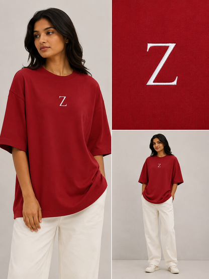 Zeroform , women oversized T-shirts  Person wearing a red t-shirt with a 'Z' logo, standing against a gray background.