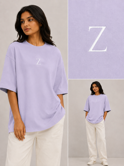 Zeroform , women oversized T-shirts  Woman wearing a light purple t-shirt with a 'Z' logo, standing against a plain background.