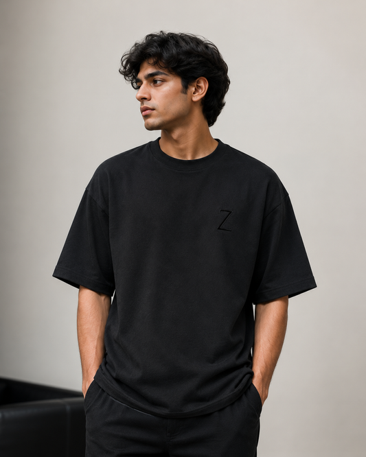zeroform | Person wearing a black t-shirt with a logo on a plain background